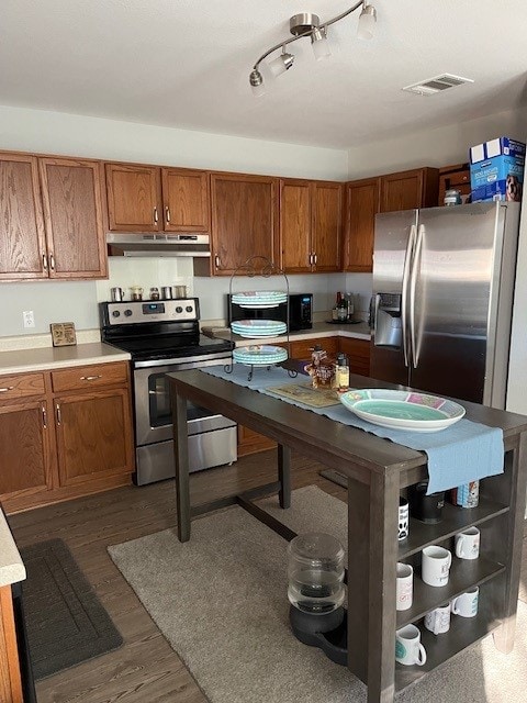 3508 Sandy Brook Dr, Round Rock, TX 78665 - kitchen featuring visible vents, brown cabinets, light countertops, under cabinet range hood, and stainless steel appliances