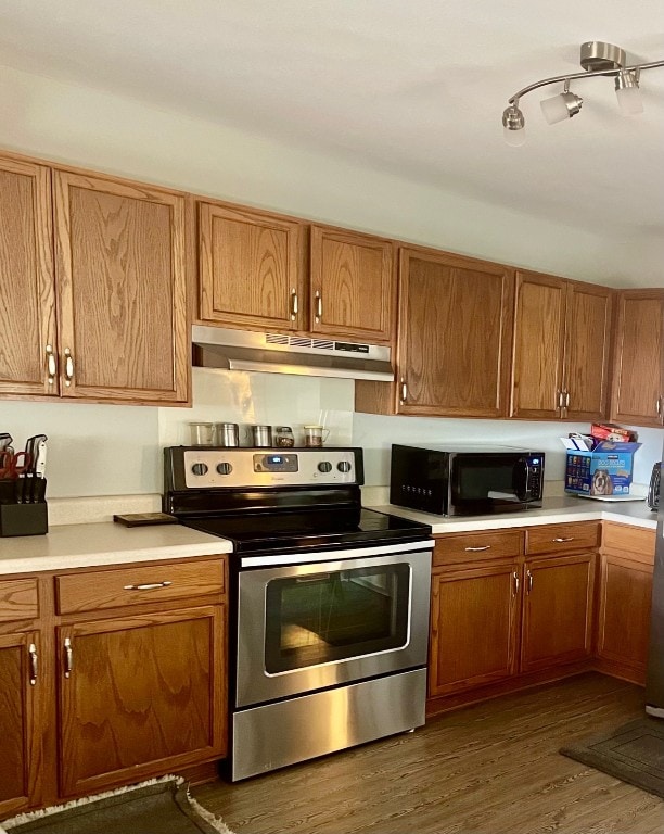 3508 Sandy Brook Dr, Round Rock, TX 78665 - kitchen with brown cabinetry, black microwave, stainless steel range with electric cooktop, light countertops, and under cabinet range hood