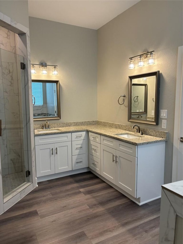 170 Nuuanu Rd, Bastrop, TX 78602 - bathroom featuring two vanities, a stall shower, and wood finished floors