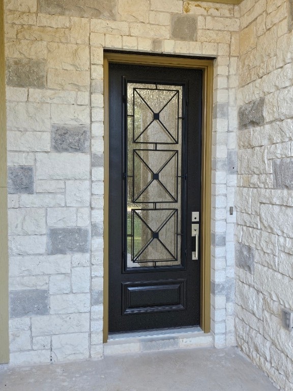 property entrance with stone siding