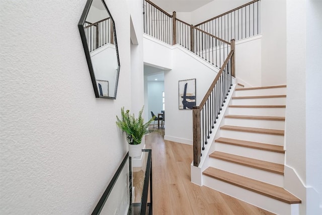 3838 Laurel Ridge Dr, Round Rock, TX 78665 - staircase with wood finished floors, a towering ceiling, baseboards, and a textured wall