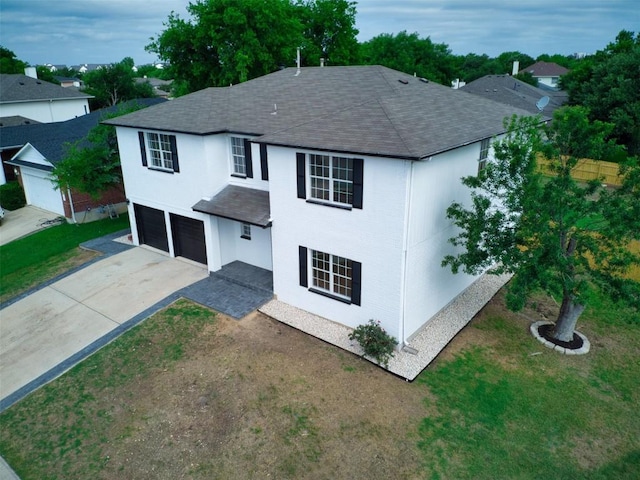 view of front facade with a garage, a shingled roof, driveway, and a front yard