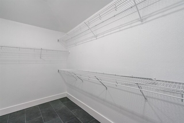 walk in closet with dark tile patterned flooring