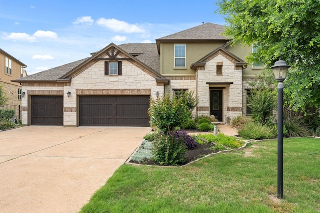 view of front of house with a shingled roof, stone siding, stucco siding, a front yard, and concrete driveway