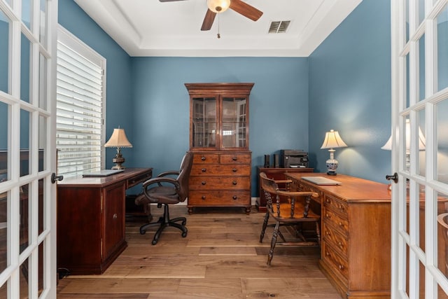 office with visible vents, wood finished floors, a raised ceiling, french doors, and a ceiling fan