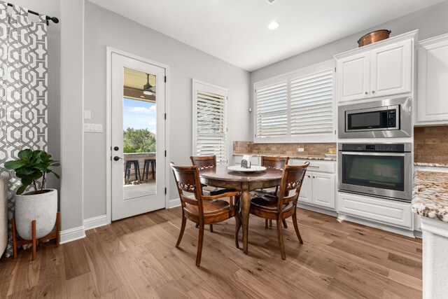 dining room with recessed lighting, light wood-style flooring, and baseboards