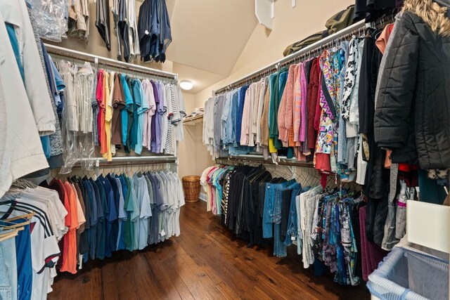 walk in closet with wood-type flooring and vaulted ceiling