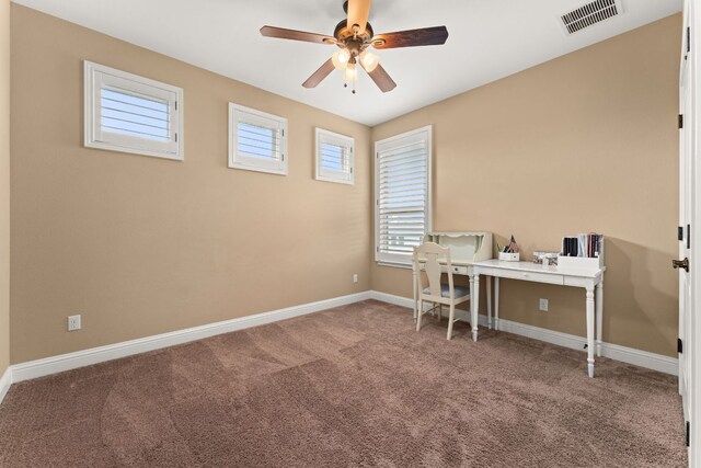 carpeted home office featuring visible vents, a ceiling fan, and baseboards
