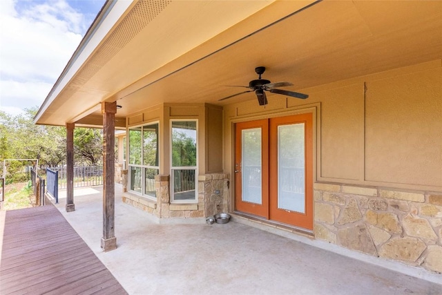 deck with ceiling fan, fence, french doors, and a patio area