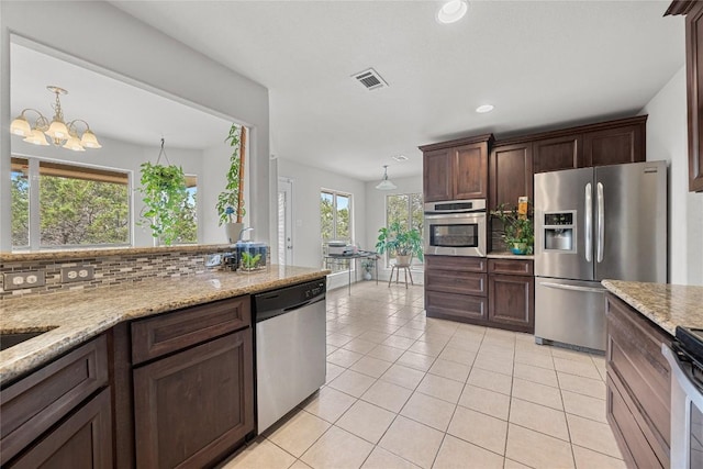 kitchen featuring dark brown cabinetry, visible vents, light tile patterned floors, an inviting chandelier, and stainless steel appliances