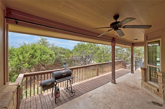 wooden terrace with grilling area and a ceiling fan