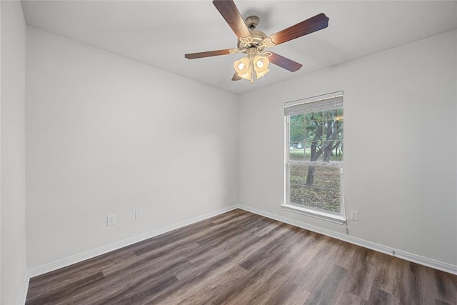 empty room with baseboards, ceiling fan, and dark wood-type flooring