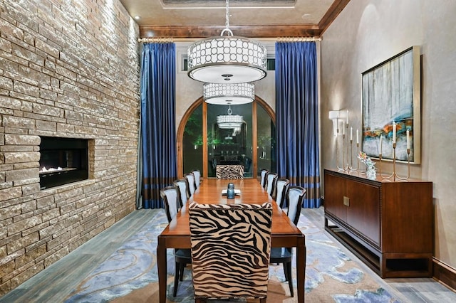 dining area with crown molding, wood finished floors, and a fireplace