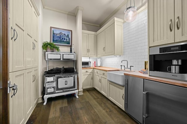 kitchen with crown molding, wooden counters, a sink, dark wood finished floors, and backsplash