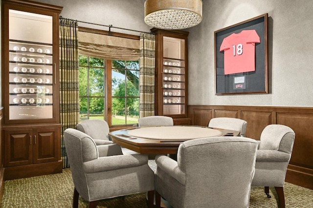 dining room featuring a decorative wall, a textured wall, and a wainscoted wall
