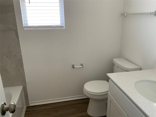 bathroom featuring walk in shower, wood finished floors, vanity, toilet, and a tub to relax in