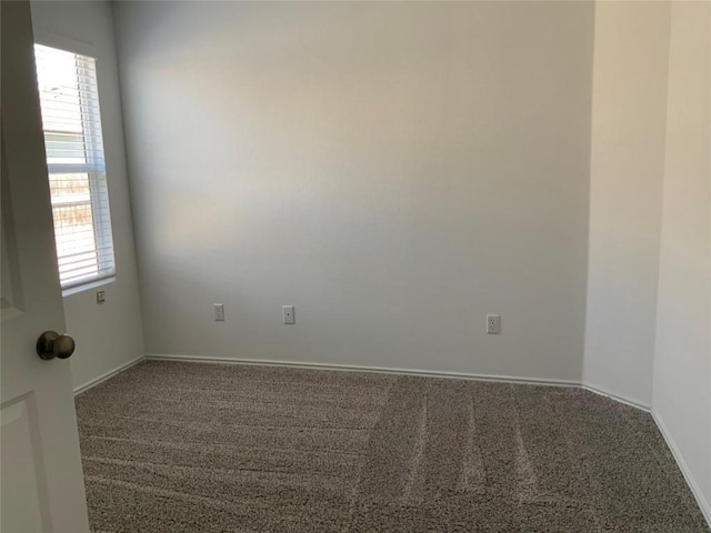 empty room featuring baseboards and carpet flooring