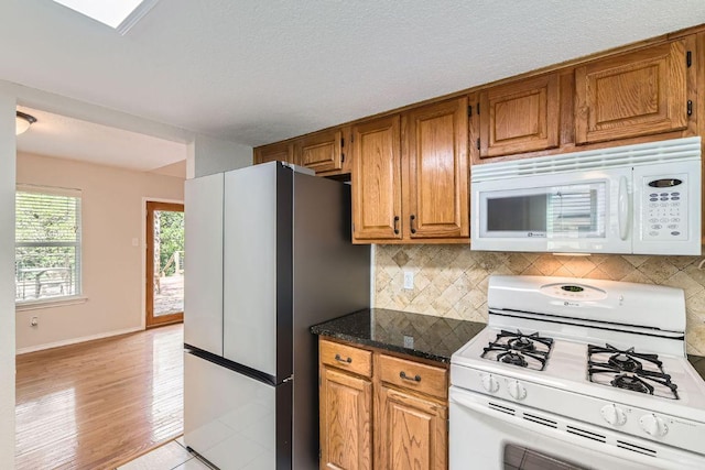 4318 Clarno Dr, Austin, TX 78749 - kitchen featuring white appliances, tasteful backsplash, brown cabinets, and light wood finished floors