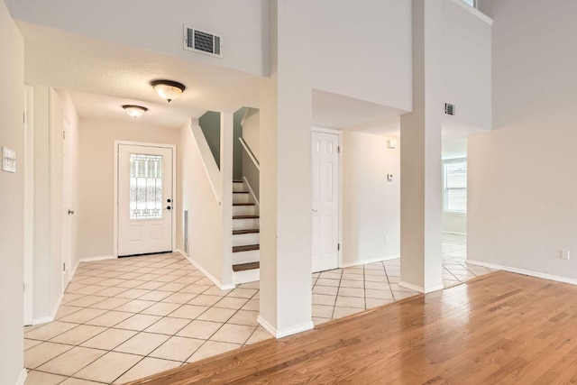 4318 Clarno Dr, Austin, TX 78749 - entrance foyer featuring stairs, light wood-style floors, a high ceiling, and baseboards