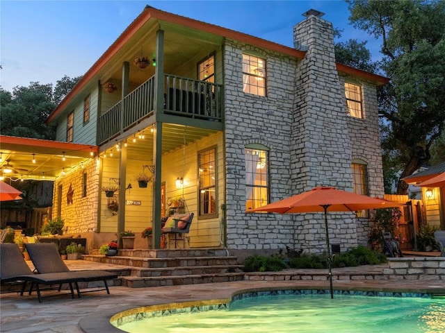 6407 Poncha Pass, Austin, TX 78749 - rear view of property featuring a balcony, a chimney, an outdoor pool, and a patio