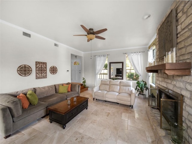 6407 Poncha Pass, Austin, TX 78749 - living room featuring crown molding, ceiling fan, stone tile floors, and a stone fireplace