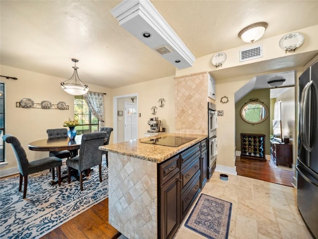 6407 Poncha Pass, Austin, TX 78749 - kitchen featuring stainless steel appliances, light stone counters, baseboards, decorative light fixtures, and dark brown cabinets