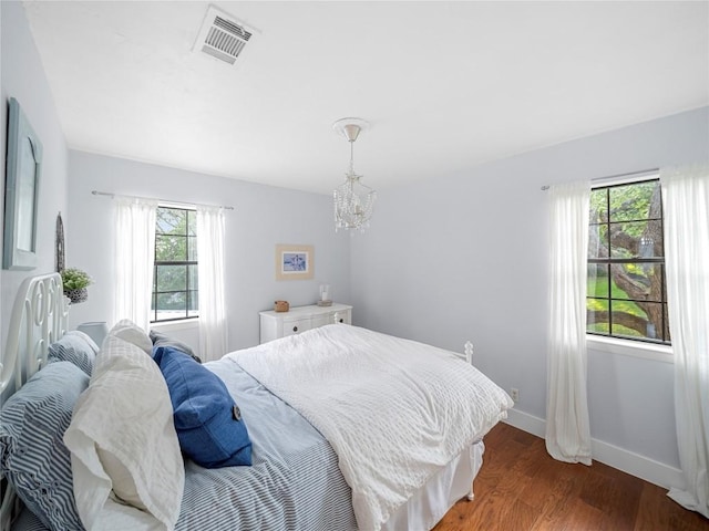 6407 Poncha Pass, Austin, TX 78749 - bedroom featuring a chandelier, wood finished floors, and baseboards