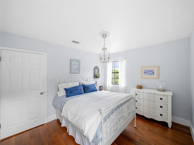 6407 Poncha Pass, Austin, TX 78749 - bedroom with dark wood-style floors, a chandelier, and baseboards