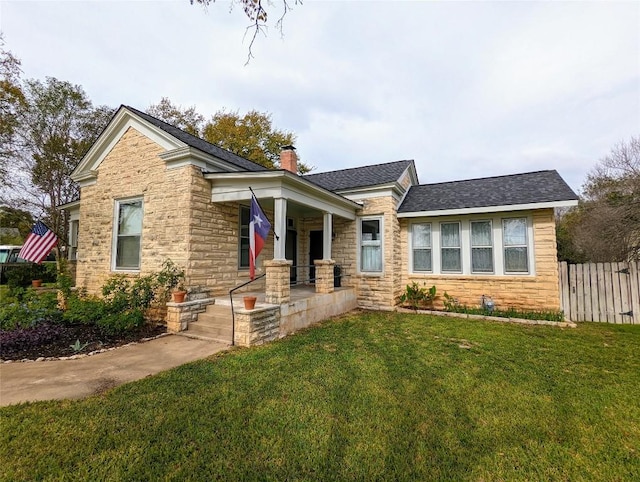 515 E 8th St, Georgetown, TX 78626 - view of front of house with a chimney, a front lawn, covered porch, and stone siding