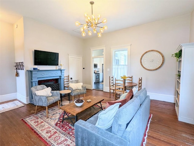 515 E 8th St, Georgetown, TX 78626 - living room with an inviting chandelier, baseboards, a fireplace, and wood-type flooring