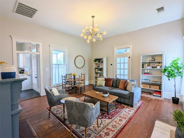 515 E 8th St, Georgetown, TX 78626 - living area with baseboards, visible vents, an inviting chandelier, and wood finished floors