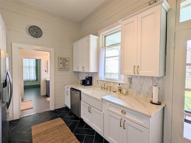 515 E 8th St, Georgetown, TX 78626 - kitchen with ornamental molding, white cabinetry, appliances with stainless steel finishes, and wooden walls