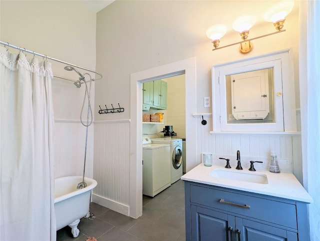 515 E 8th St, Georgetown, TX 78626 - full bath with vanity, tile patterned floors, independent washer and dryer, and a wainscoted wall
