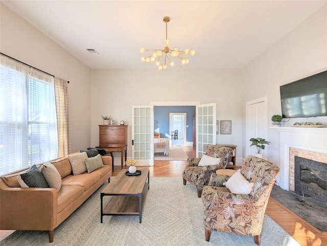 515 E 8th St, Georgetown, TX 78626 - living area featuring light wood-style floors, a wealth of natural light, and a notable chandelier