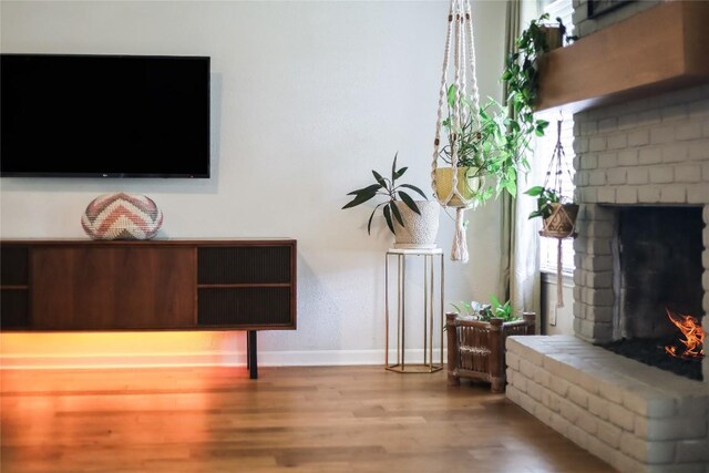 living room with baseboards, a fireplace, and wood finished floors