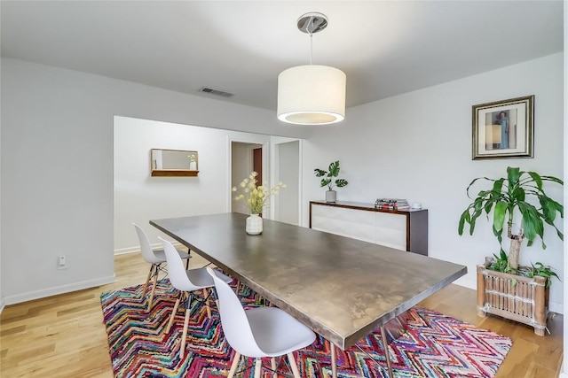 dining area with visible vents, baseboards, and light wood-type flooring