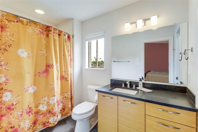 full bath with tile patterned flooring, ensuite bath, toilet, and vanity