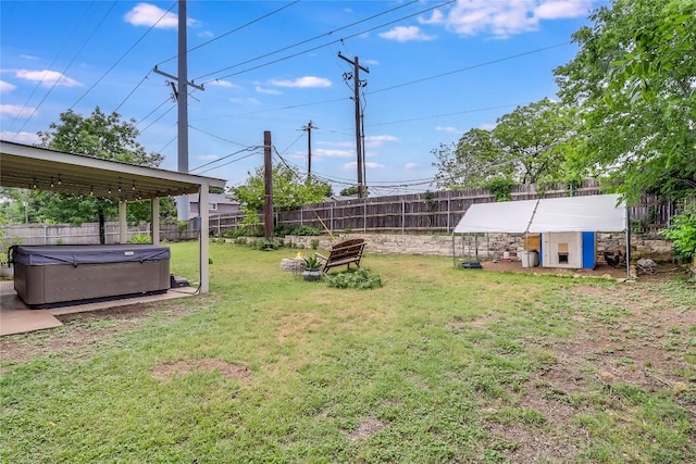 view of yard with an outdoor structure, a fenced backyard, a hot tub, and exterior structure