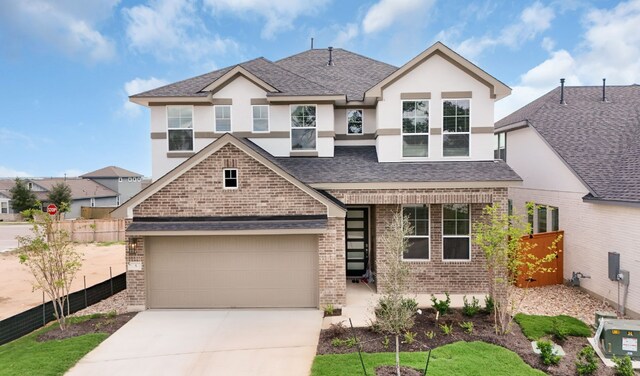 2705 Sage Ranch Dr Unit 22, Leander, TX 78641 - view of front facade featuring brick siding, concrete driveway, a garage, stucco siding, and roof with shingles