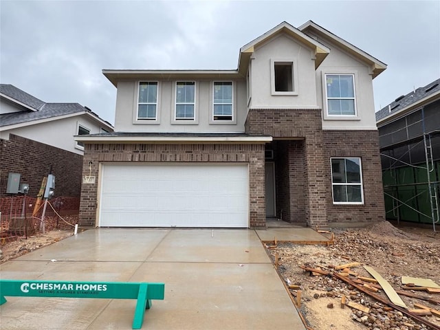 2705 Sage Ranch Dr Unit 22, Leander, TX 78641 - view of front of home featuring brick siding, an attached garage, driveway, and stucco siding