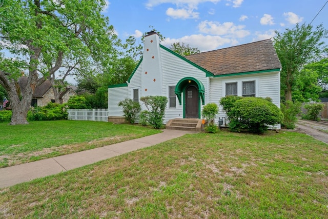 view of front of property featuring fence, a chimney, and a front yard