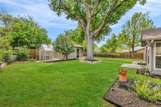view of yard with an exterior structure, an outbuilding, and a fenced backyard