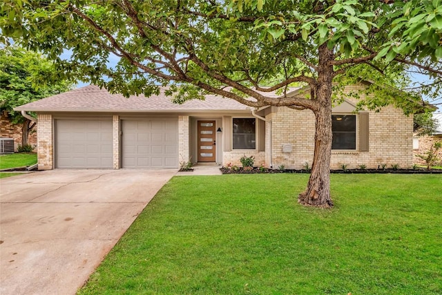 view of front of house featuring a garage, a front lawn, brick siding, concrete driveway, and central air condition unit