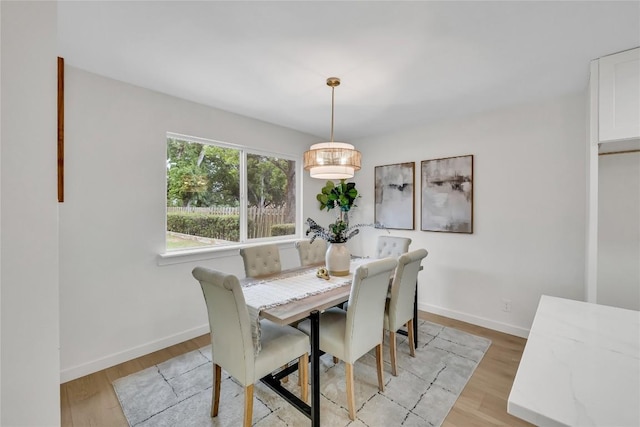 dining room featuring baseboards and light wood finished floors