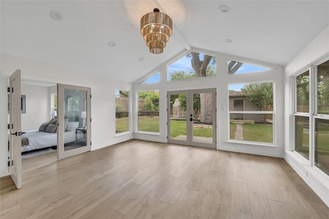 unfurnished sunroom featuring beamed ceiling, an inviting chandelier, and french doors