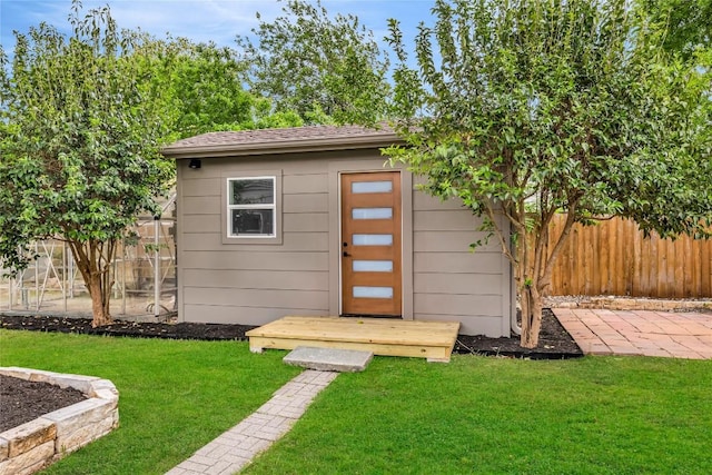 view of outbuilding featuring fence and an outdoor structure