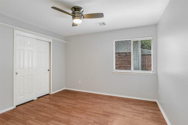 unfurnished bedroom with visible vents, a closet, light wood-style floors, baseboards, and a ceiling fan