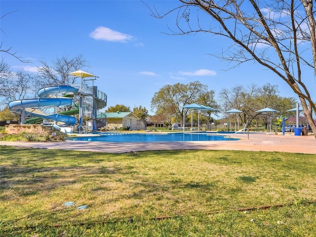 community pool with a yard and a water slide