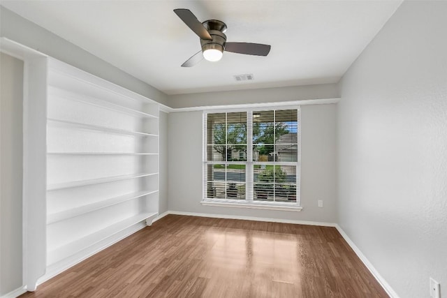 empty room with visible vents, baseboards, ceiling fan, and wood finished floors