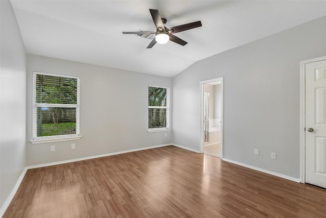 unfurnished bedroom with baseboards, multiple windows, and wood finished floors